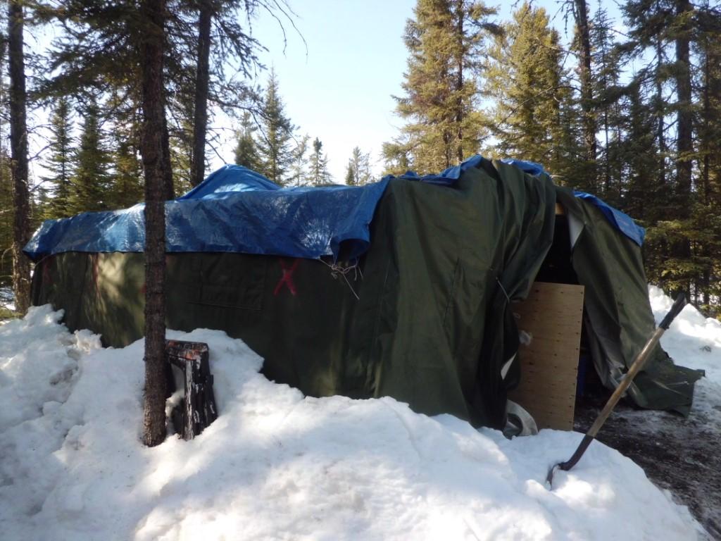 Tarp covering a collapsed tent in snow.