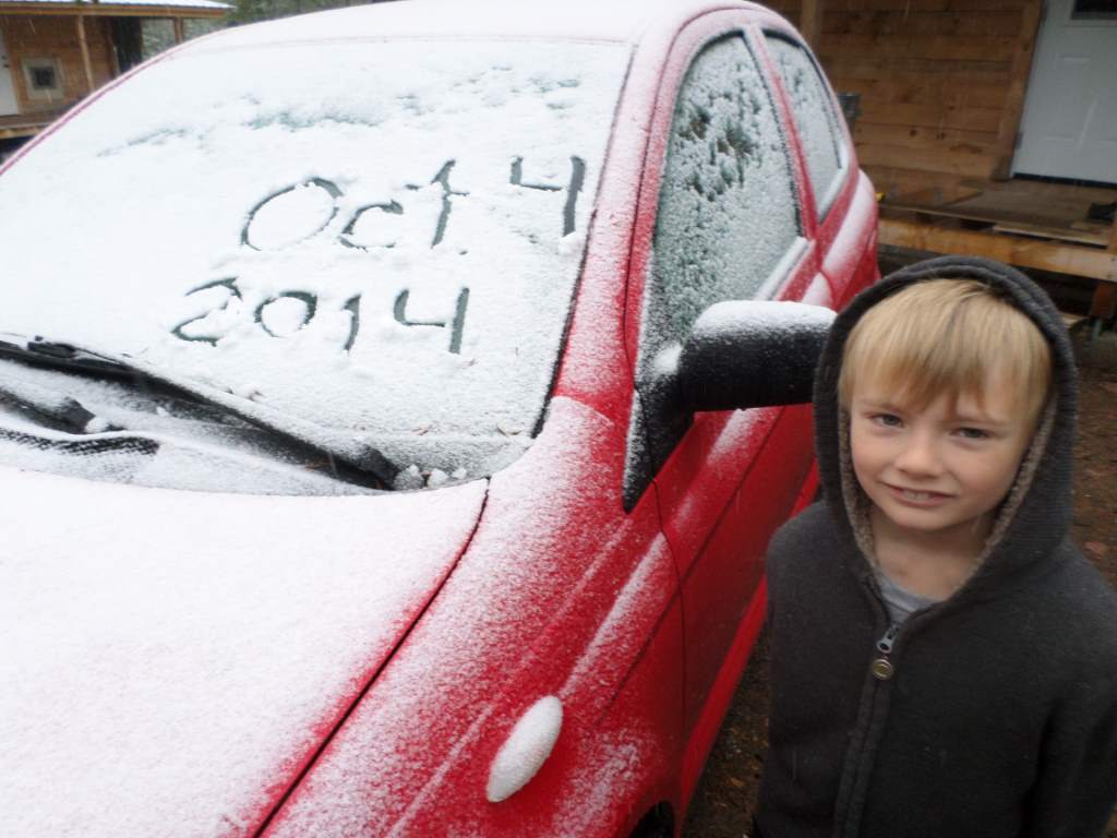 Car windscreen with "Oct 4 2014" drawn in snow.