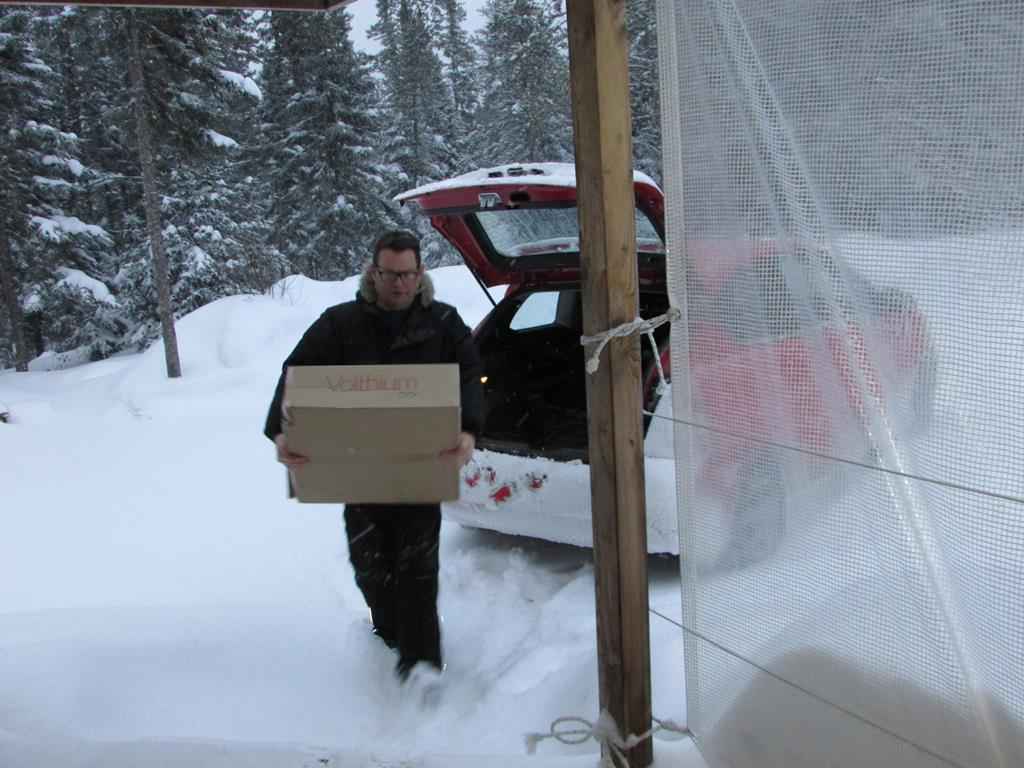 Man carrying a box in the snow.
