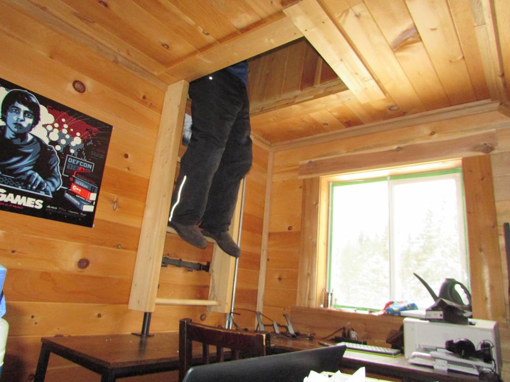 Legs hanging down from an open attic door.