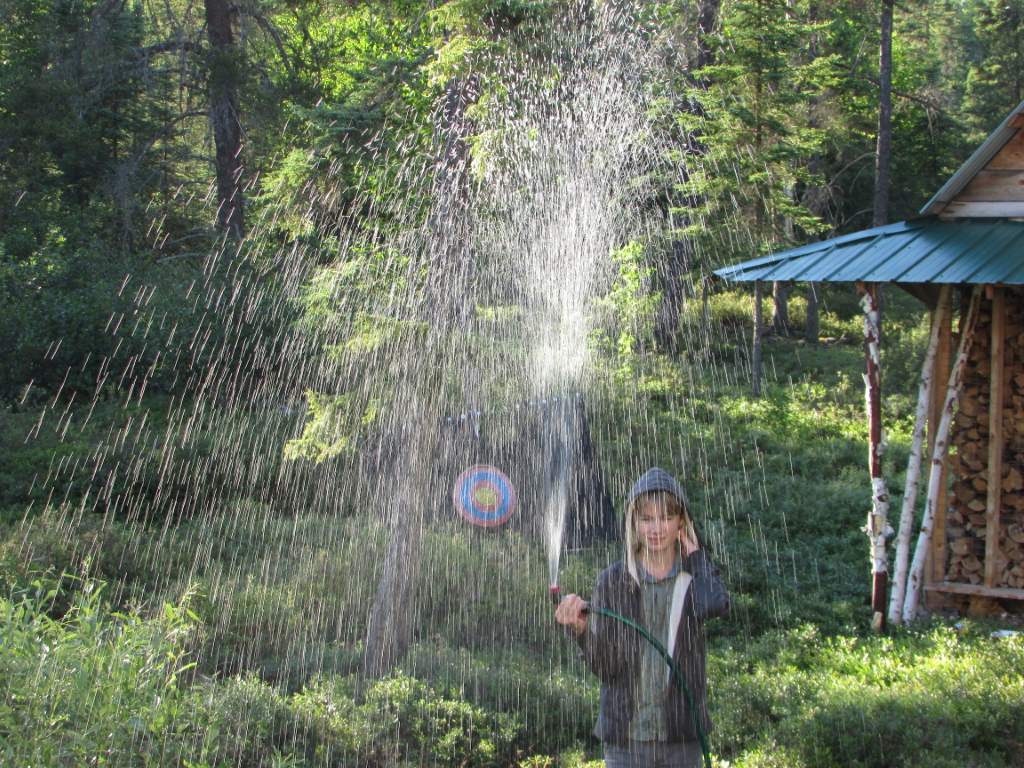 Young boy spraying water into the air.