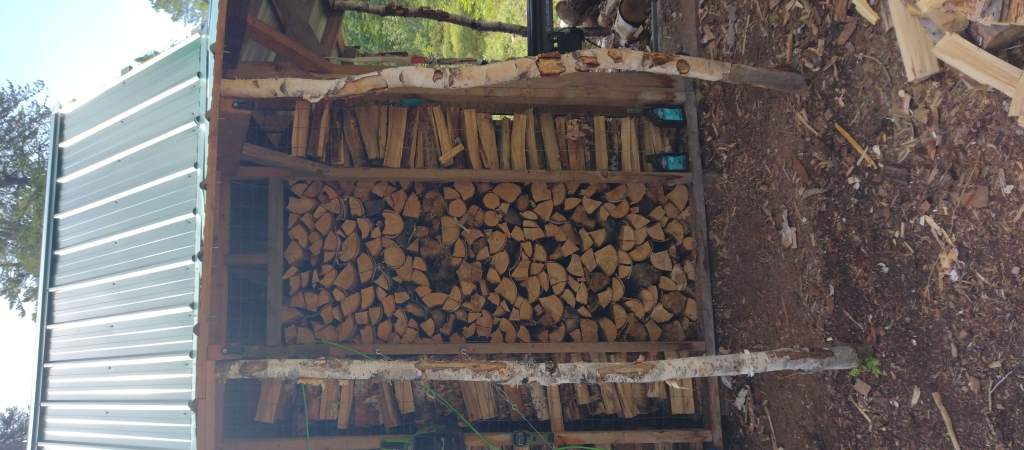 A woodshed filled to the top.